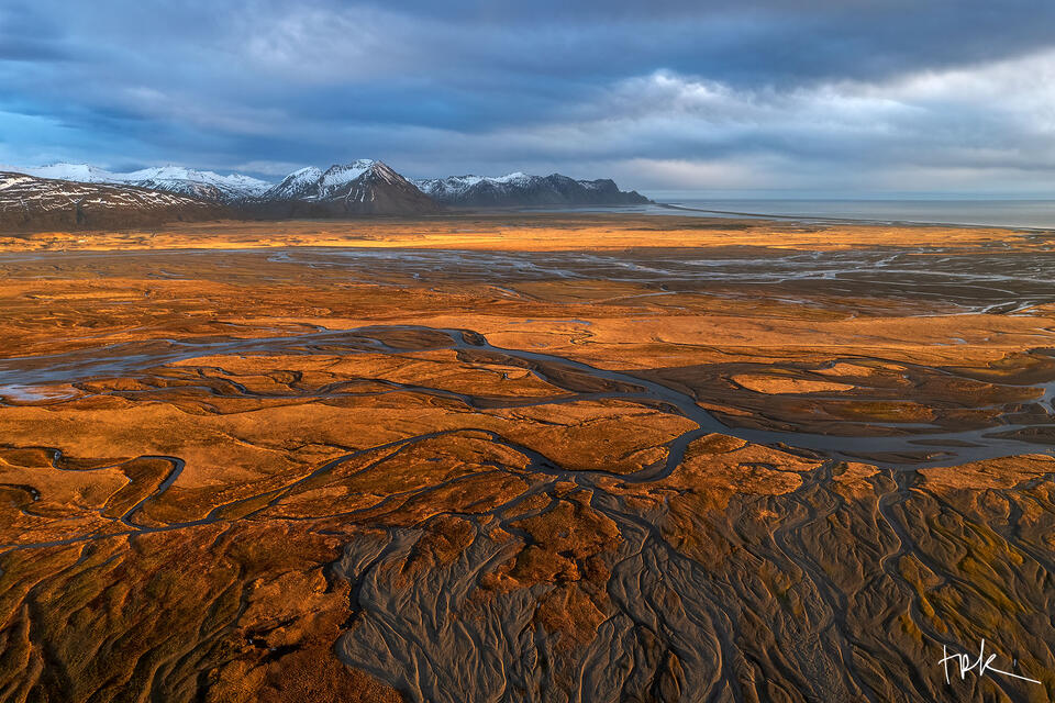 Limited edition print of an Icelandic river delta at sunrise with the surrounding grass taking on a warm yellow-red tone.