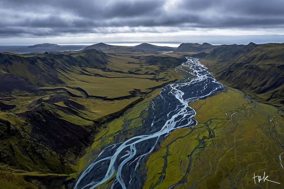 Limited edition print of an Icelandic braided river leading to mountains and the ocean beyond.