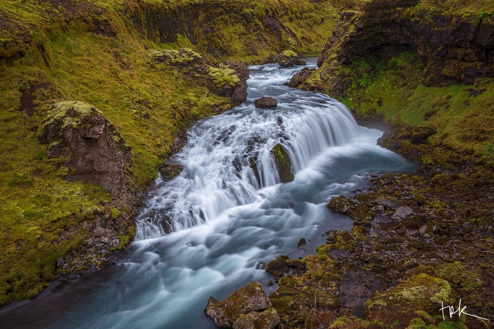 Limited edition print of a wide Icelandic waterfall in a moss-filled canyon.