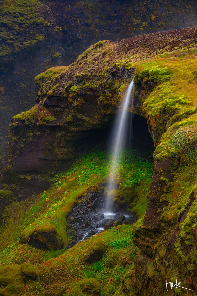 Limited edition print of a small Icelandic thread-like waterfall illuminated by the sun.