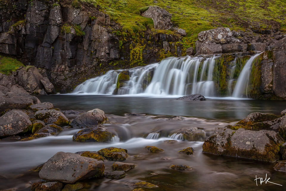 Limited edition print of a short but wide Icelandic waterfall with some stones in the foreground.