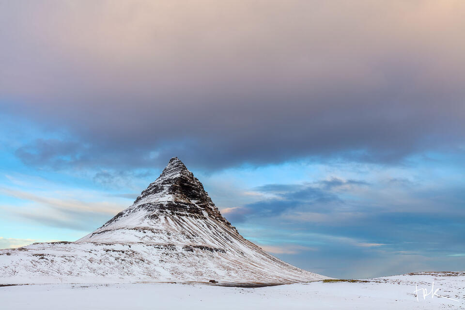 Limited edition print of a snow-covered Kirkjufell under a pastel-colored sunrise sky.