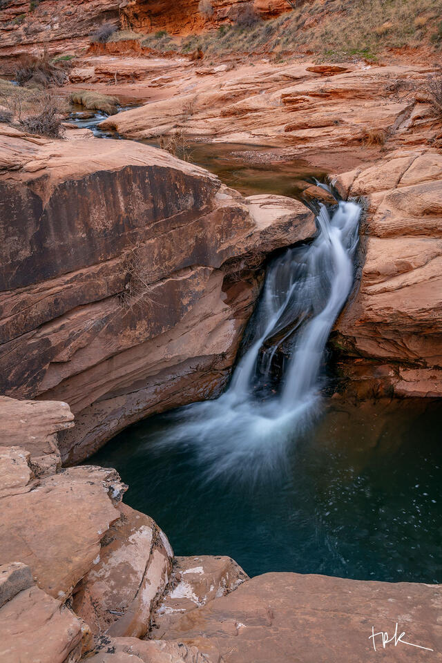 Limited edition print of a desert waterfall near Moab, Utah, rushing over pink-colored sandstone.