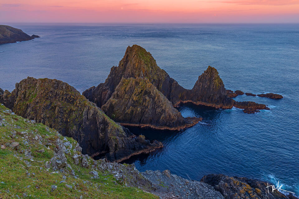 Limited edition print of a series of triangle-shaped sea stacks off the coast of Shetland at sunrise.