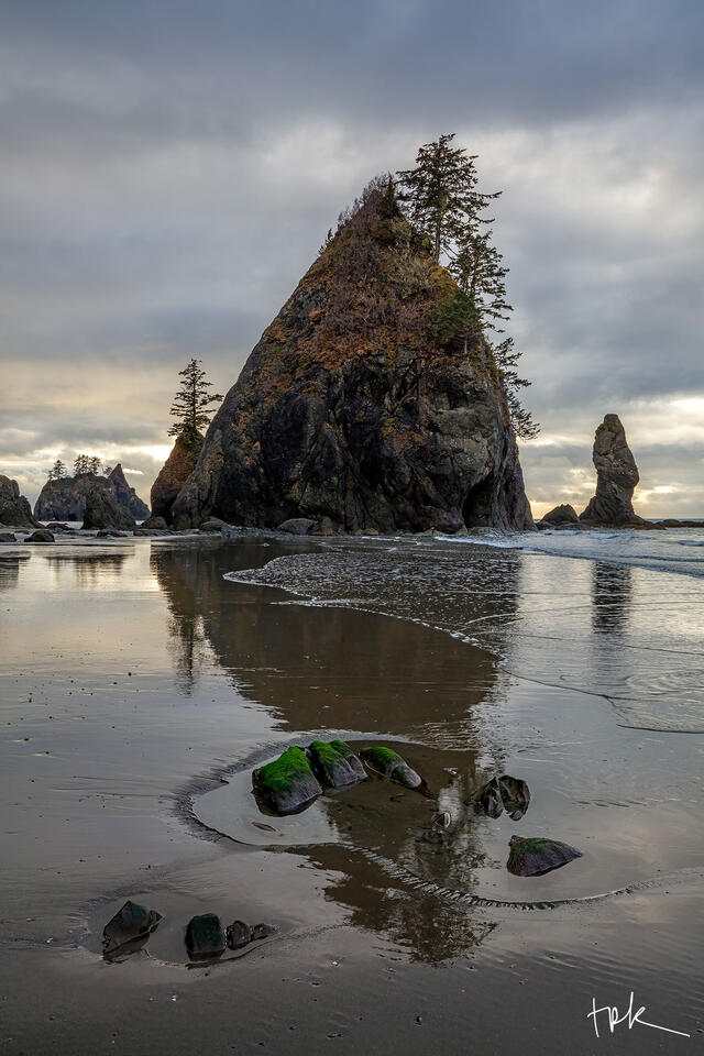 Limited edition print of a triangular-shaped sea stack reflected in the wet sand at Washington’s Point of Arches.