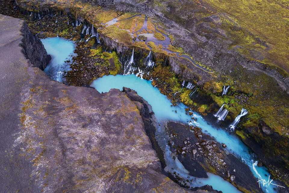 Limited edition print of the canyon, Sigöldugljúfur, in the Icelandic highland where many small waterfalls pour from a cliff face into a turquoise river.