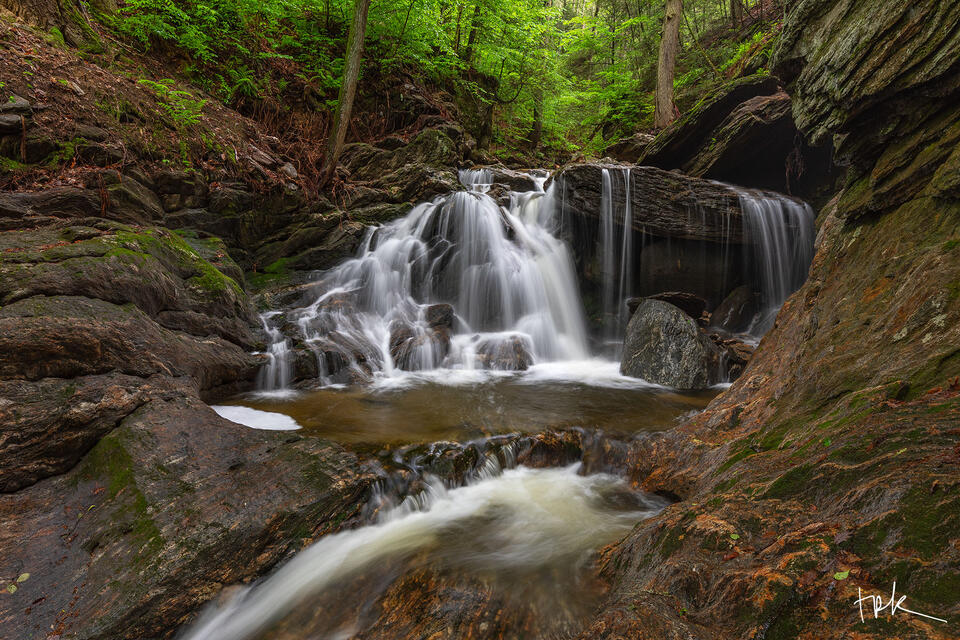 Limited edition print of the first falls at Spruce Brook in Beacon Falls, Connecticut in spring under a canopy of green leaves.