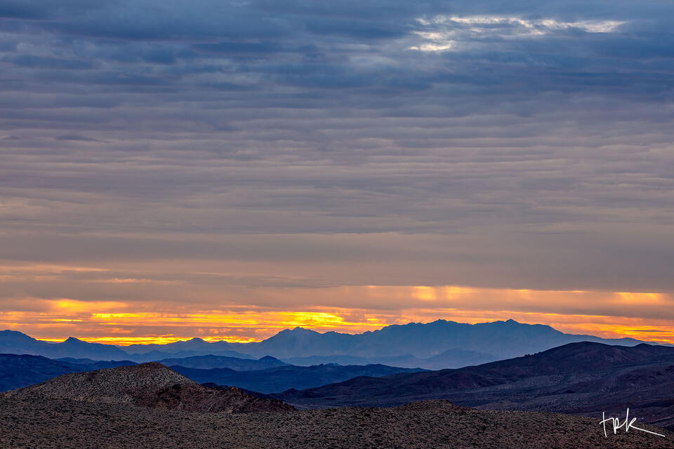 Limited edition print of textured clouds over mountain peaks during sunrise at Death Valley National Park.