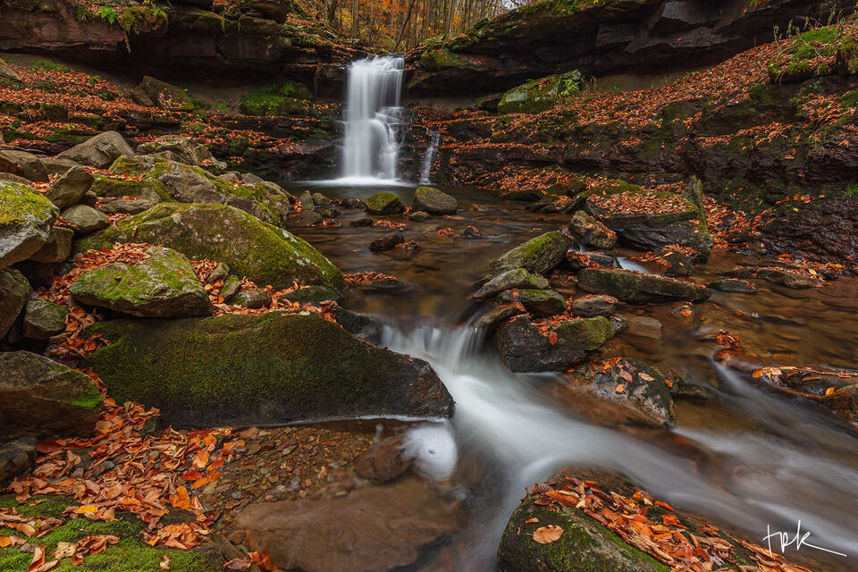 Limited edition print of a Pennsylvania waterfall plunging over a ledge viewed from downstream during autumn.