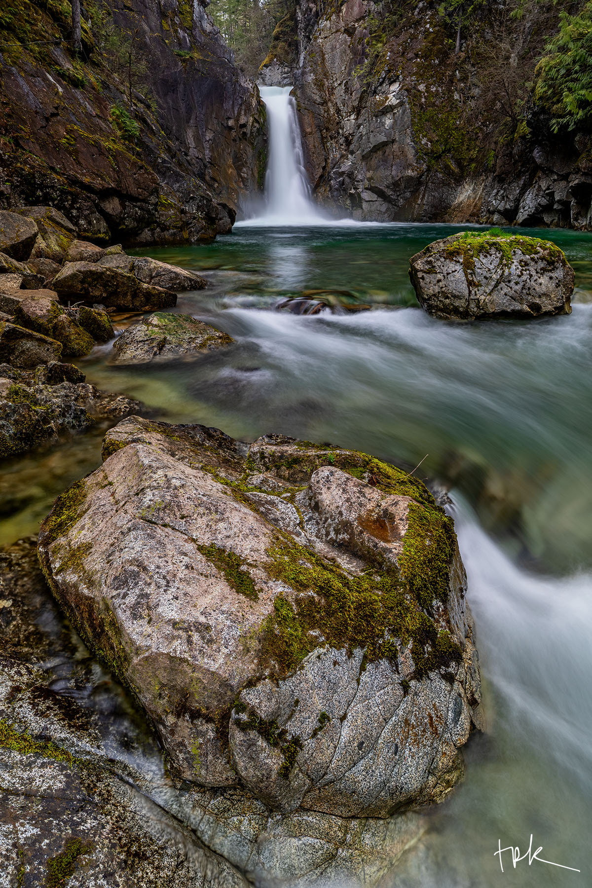Spillway Limited edition print of a waterfall gorge with a large boulder in the foreground, partially covered with moss.
